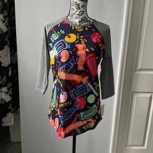 Navy shirt with gray sleeves and large wrapped candy pieces